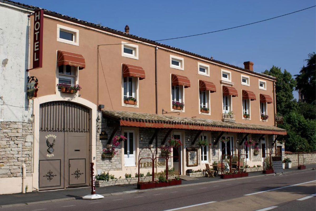 Façade du Relais de l'Abbaye, hôtel-restaurant à Tournus, avec sa terrasse fleurie en bord de route